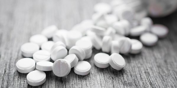 Prescription pills spilled over a wooden table