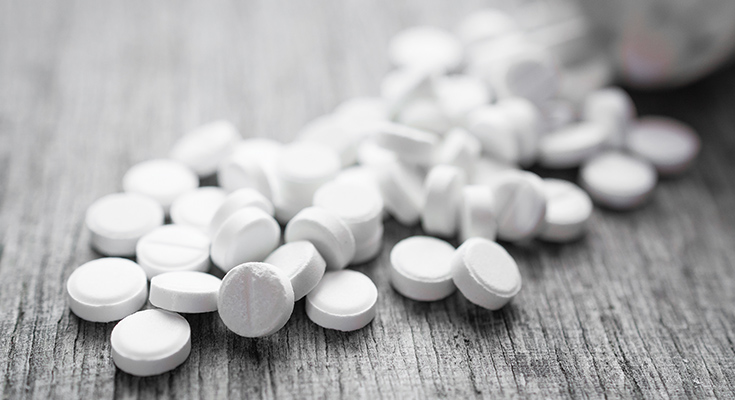 Prescription pills spilled over a wooden table