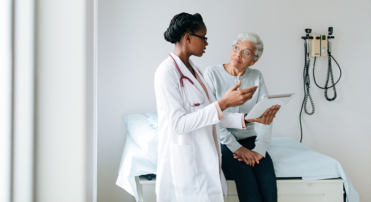 A physician speaks to an elderly patient