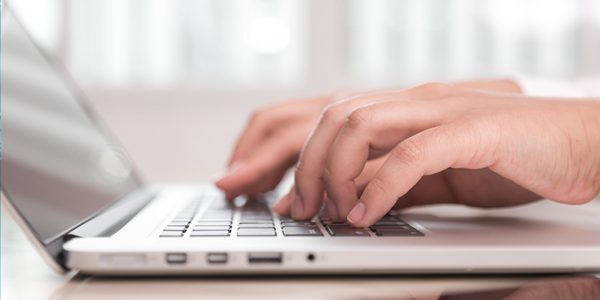 Close-up of hands on a laptop keyboard