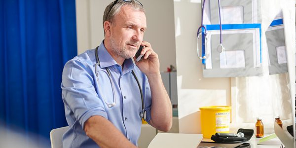 A man speaking on a phone in a medical office