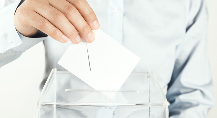 Person dropping a ballot into a box
