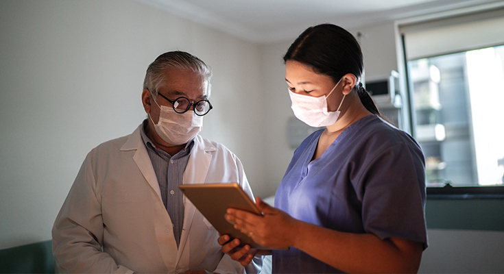 A physician reviews a chart with an assistant