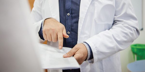 A physician pointing to something on a chart