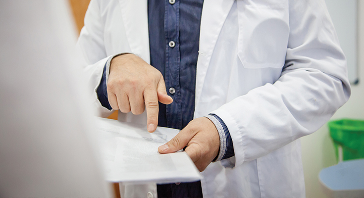 A physician pointing to something on a chart