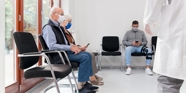 Masked patients sitting in a waiting room