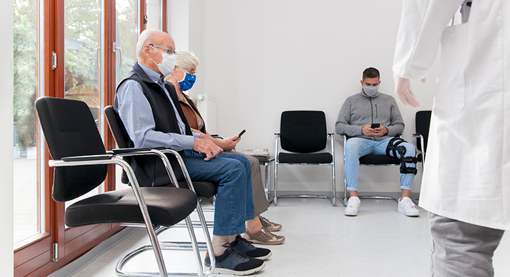 Masked patients sitting in a waiting room