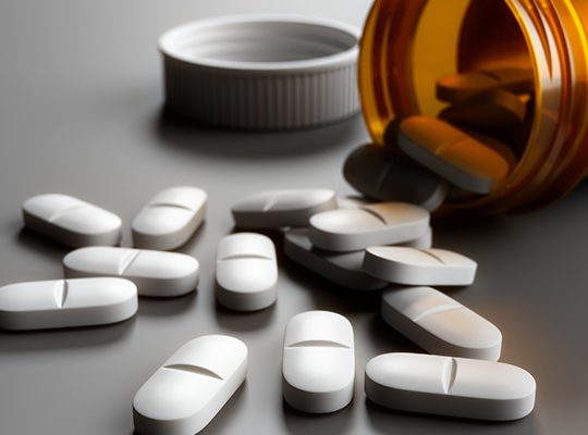 White pills spilled from an open prescription bottle