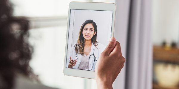 Someone video conferencing with a physician on their tablet