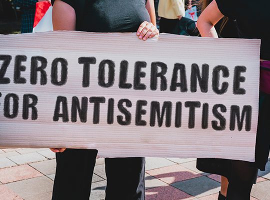 Someone holding a sign: "Zero tolerance for antisemitism"