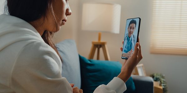 A patient video conferencing with their physician via a smartphone