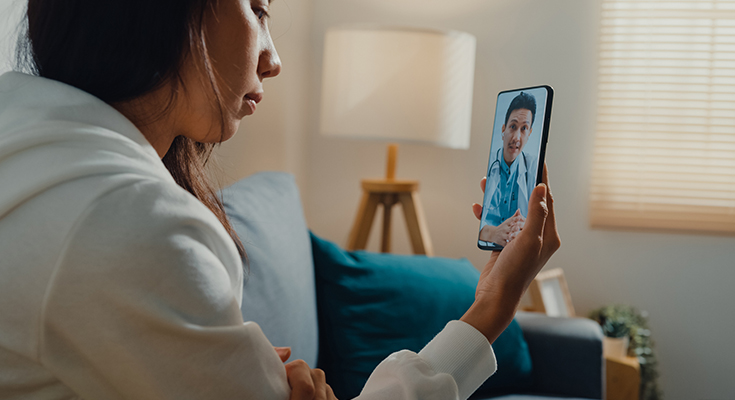 A patient video conferencing with their physician via a smartphone