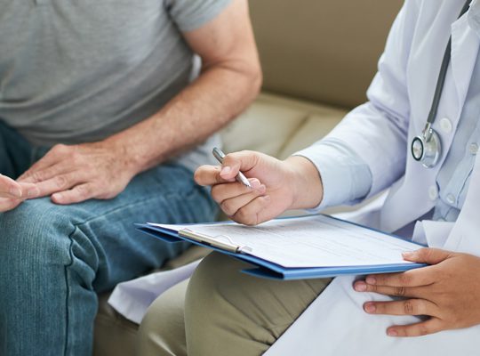 A physician consults with a patient.