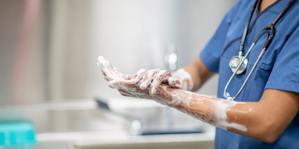 A health care worker washing their hands.