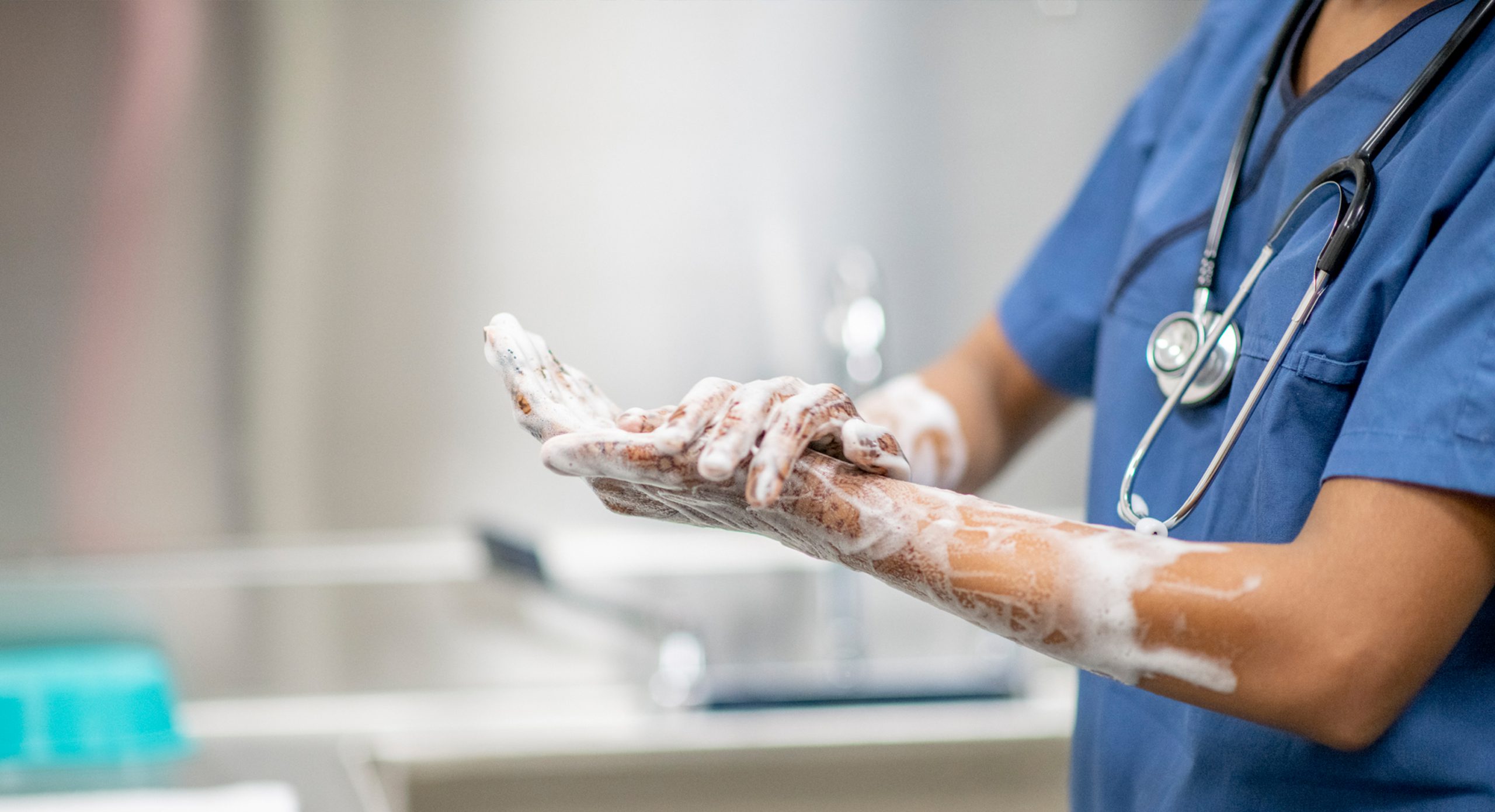 A health care worker washing their hands.